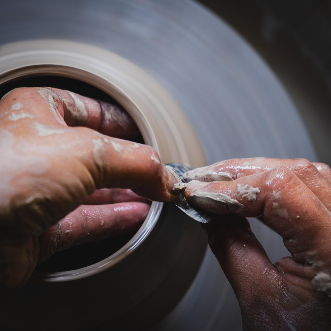 Töpferscheibe in Aktion - Hände formen Ton beim Drehen