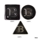 Drei Botz Pro Keramikfliesen, jeweils mit dem erhabenen Buchstaben B – ein Quadrat (1050 °C), ein Kreis (1150 °C) und ein Dreieck (1250 °C) – zeigen Farbveränderungen bei unterschiedlichen Brenntemperaturen. Die Zahl 9312 befindet sich in der unteren rechten Ecke.