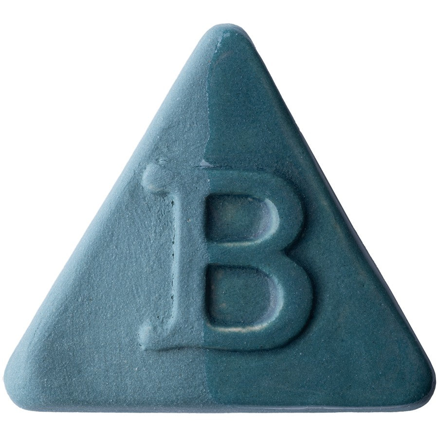 Eine blaugrüne, dreieckige Tafel mit der Aufschrift „B“ in der Mitte – ihre matte, leicht strukturierte Oberfläche lässt auf eine transparente Glasur schließen oder ist möglicherweise mit Steinzeug-Engoben der Botz Edition gefertigt.