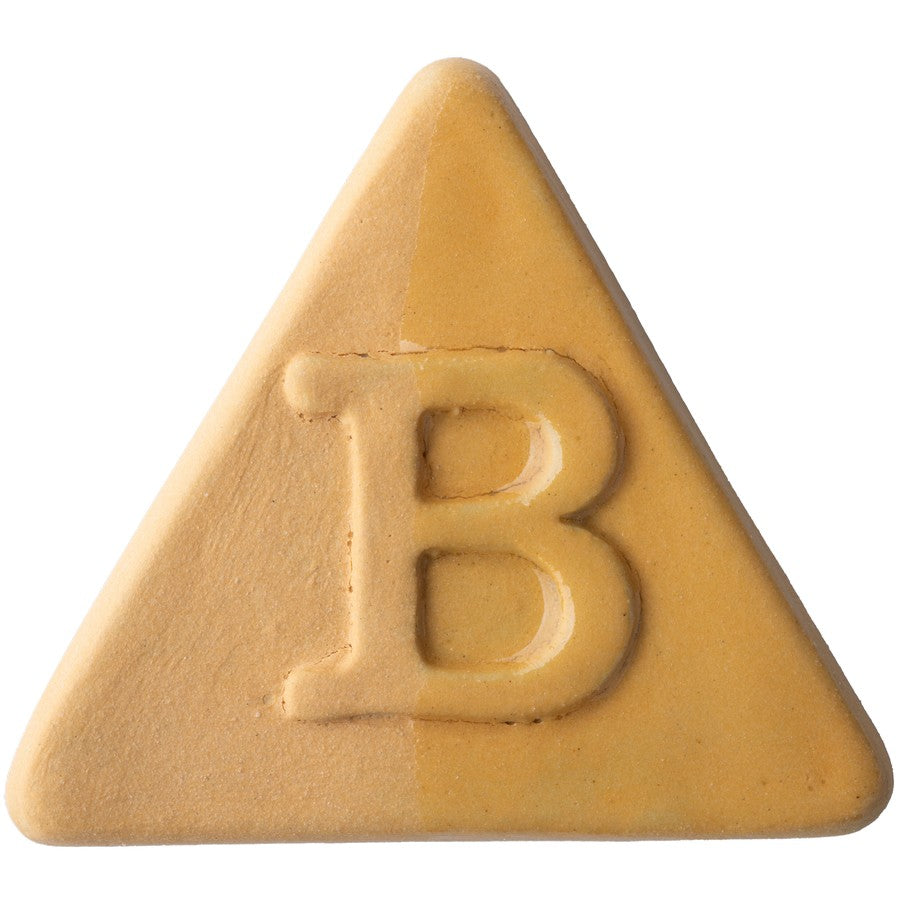 Die Botz Edition ist ein hellbrauner, dreieckiger Keks mit einem in der Mitte eingeprägten „B“ und einer transparenten Glasur auf weißem Hintergrund.