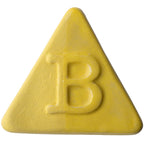 Botz Edition ist eine solide gelbe, dreieckige Tafel mit abgerundeten Kanten und einer zentralen B-Prägung, die mit transparenter Glasur für Glanz veredelt und für Brenntemperaturen von 1180–1280 °C ausgelegt ist.