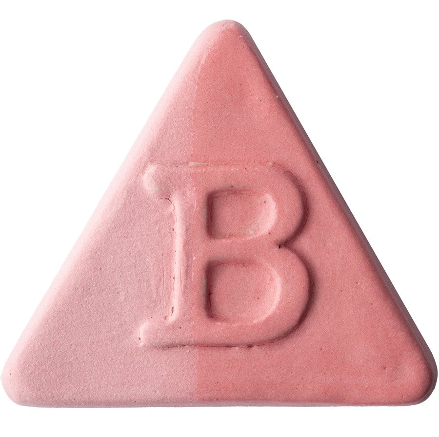 Auf weißem Hintergrund ist eine rosafarbene, dreieckige Tafel der Botz Edition mit einem in der Mitte eingeprägten „B“ und einer transparenten Glasuroberfläche abgebildet.