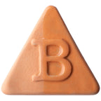Eine dreieckige, pfirsichfarbene Pille mit einem auf einer Seite eingeprägten „B“, inspiriert von der Botz Edition, die an Steinzeug-Engoben-Keramik mit transparenter Glasur erinnert.