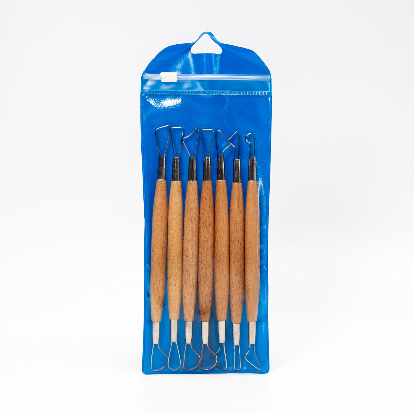Das Modellierschlingen-Set 7-teilig umfasst sieben doppelseitige Werkzeuge mit Holzgriffen, übersichtlich angeordnet in einem blauen Kunststoffbeutel mit Aufhängeloch – ideal zum Ausprobieren verschiedener Modelliertechniken und -varianten.