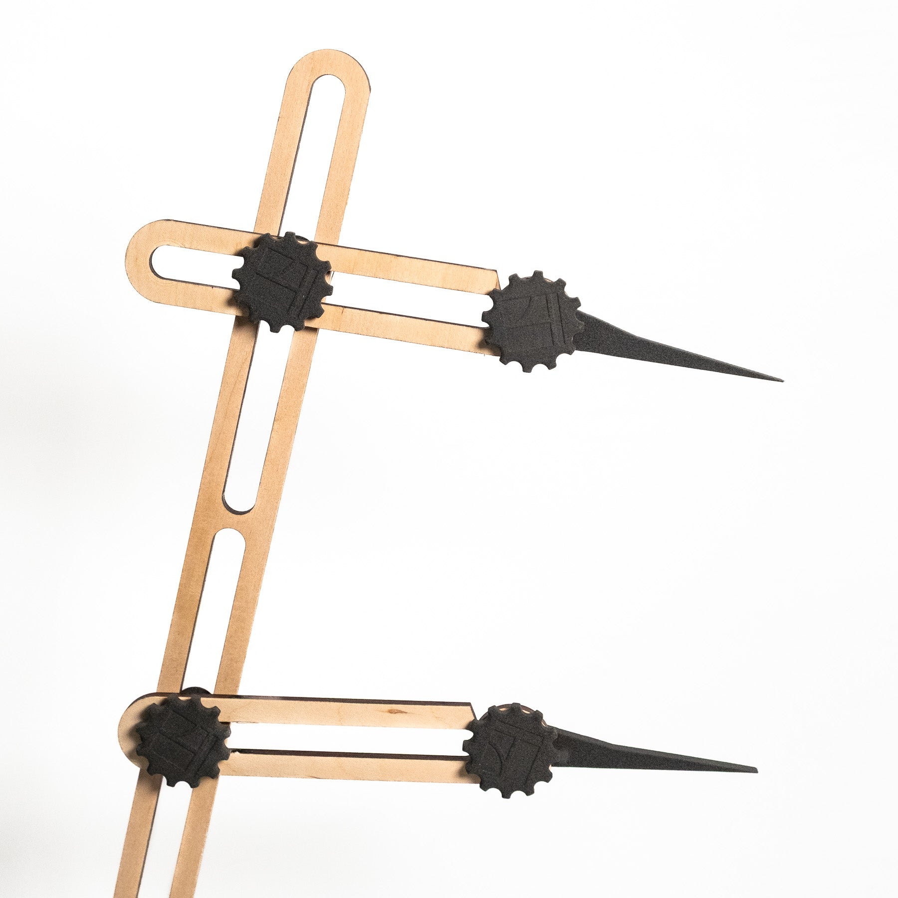 Eine Nahaufnahme des Stechmaßes - Höhenmaßes, eines geometrischen Werkzeugs mit verstellbaren Armen aus Holz und schwarzem Kunststoff und spitzen Enden, diagonal angeordnet auf einem schlichten weißen Hintergrund.