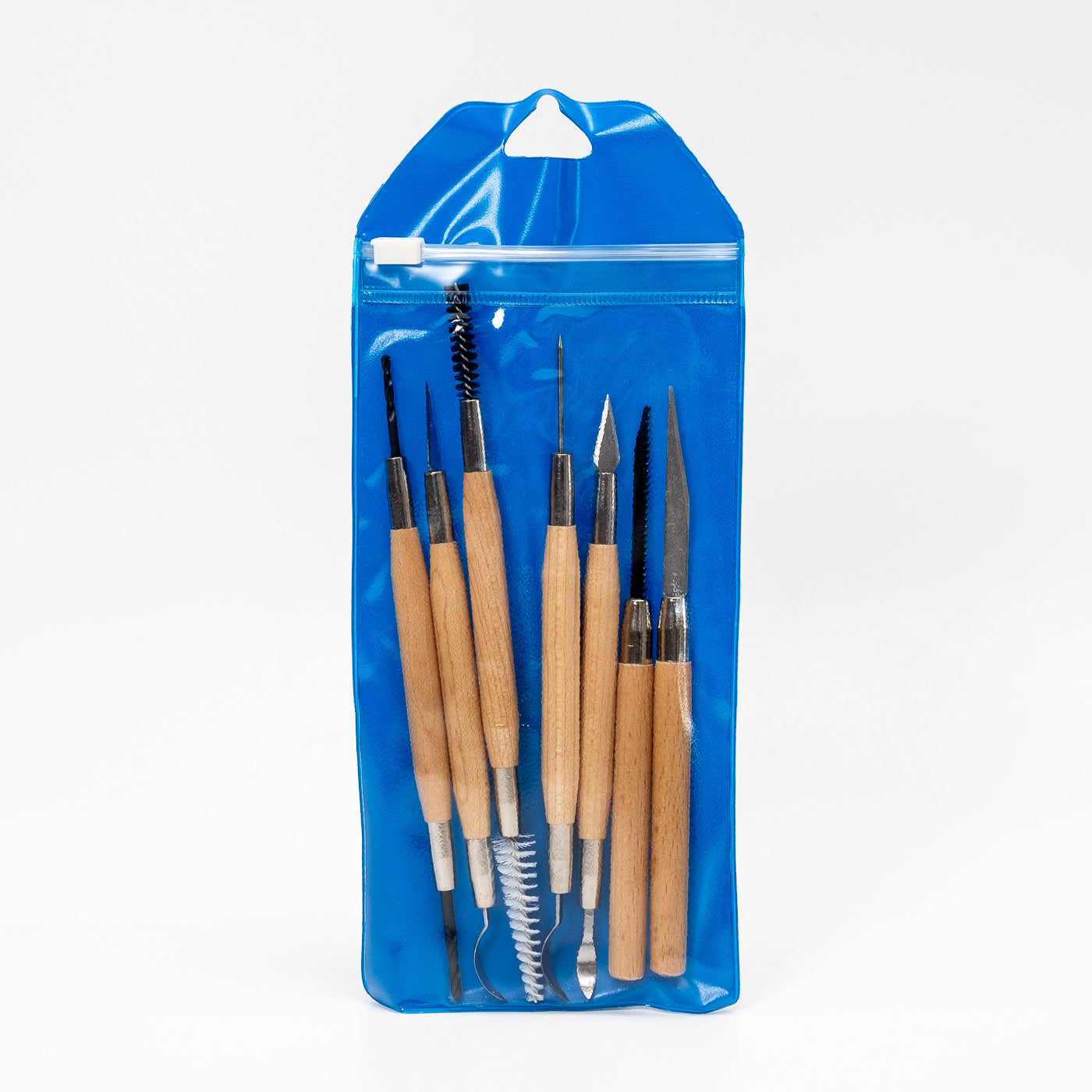 Ein blauer Kunststoffbeutel mit dem 7-teiligen Werkzeugset mit Holzschaft. Darin sind Modellierwerkzeuge mit Holzgriffen und Metallspitzen enthalten, darunter Pinsel, Spachtel und spitze Instrumente – alles ordentlich angeordnet.